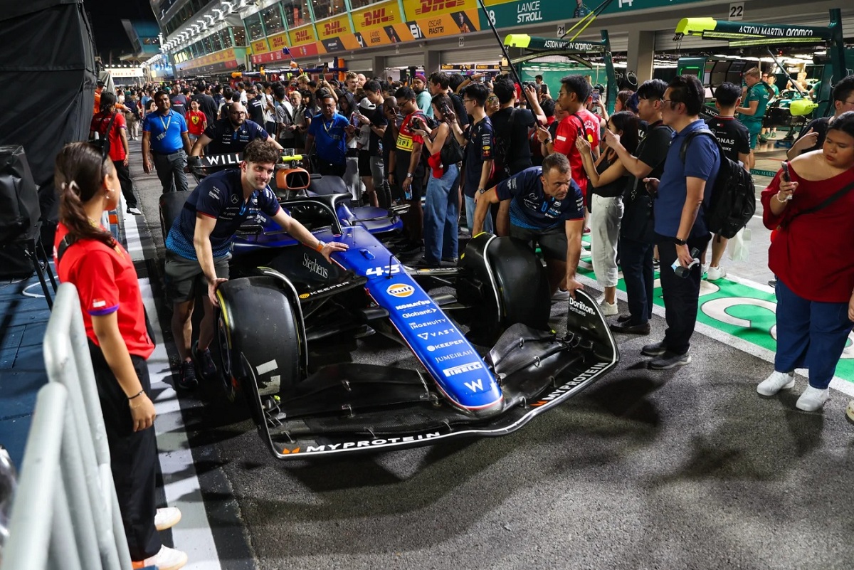 Los mecánicos de Williams trasladan el coche de Colapinto al box después de un control de FIA. (Lionel Ng)